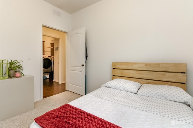 carpeted bedroom featuring washer / dryer