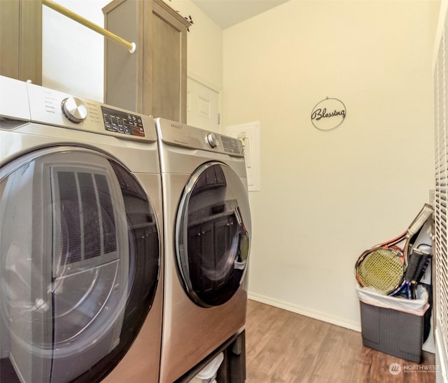 clothes washing area featuring separate washer and dryer and wood-type flooring