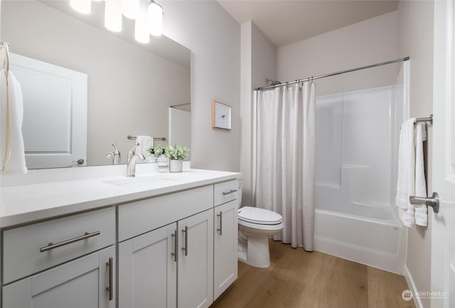 bathroom with shower / bathtub combination with curtain, vanity, toilet, and wood finished floors