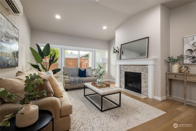 living area featuring lofted ceiling, recessed lighting, a fireplace, wood finished floors, and a wall mounted air conditioner