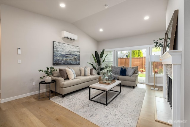 living area with a fireplace, baseboards, vaulted ceiling, light wood-type flooring, and a wall mounted air conditioner