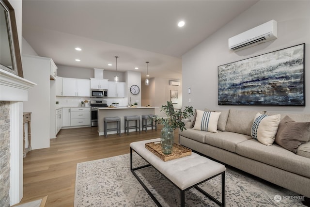 living area featuring light wood-style floors, recessed lighting, and a wall mounted air conditioner