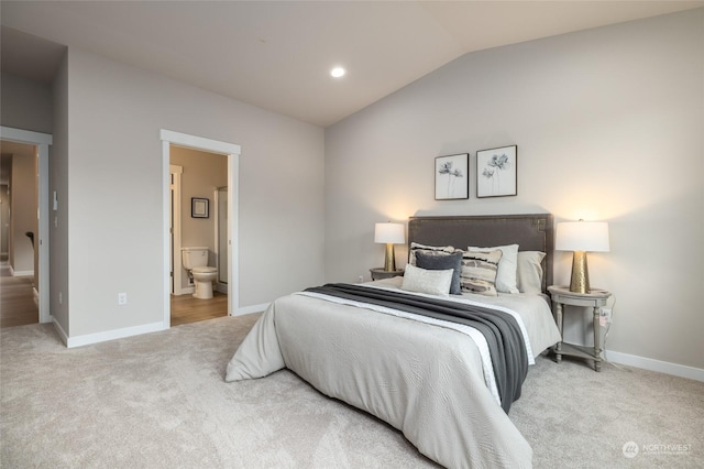 bedroom with connected bathroom, carpet flooring, vaulted ceiling, and baseboards