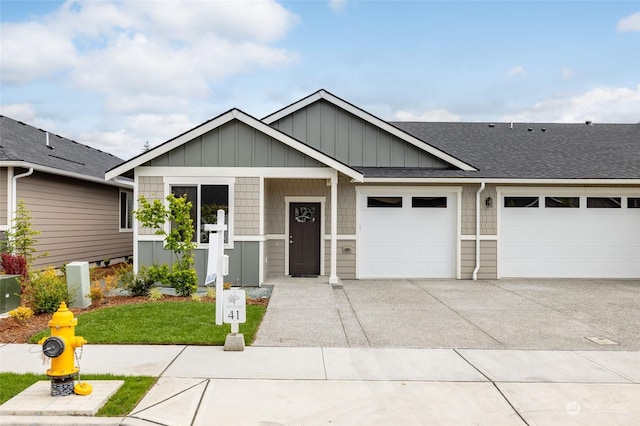 view of front facade with an attached garage, board and batten siding, a shingled roof, and concrete driveway