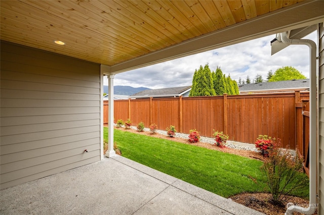 view of yard featuring a patio area, fence, and a mountain view