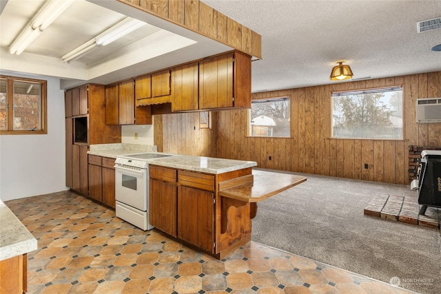 kitchen featuring light carpet, a textured ceiling, electric range, and wooden walls