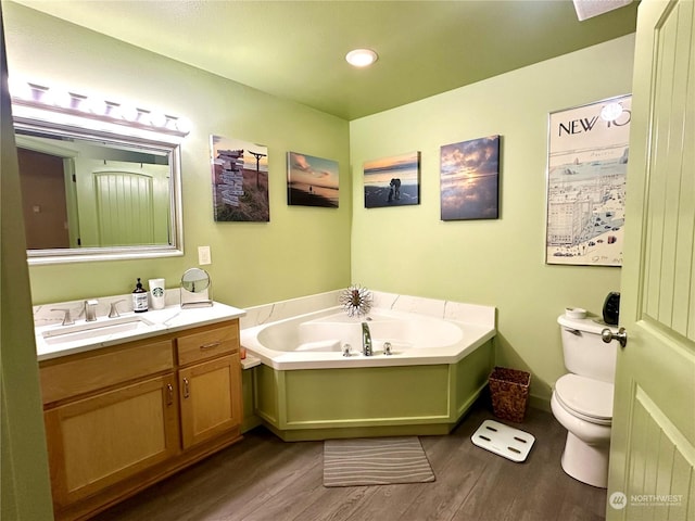 bathroom featuring hardwood / wood-style flooring, a bathtub, toilet, and vanity