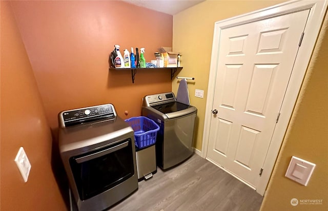 washroom with separate washer and dryer and hardwood / wood-style floors