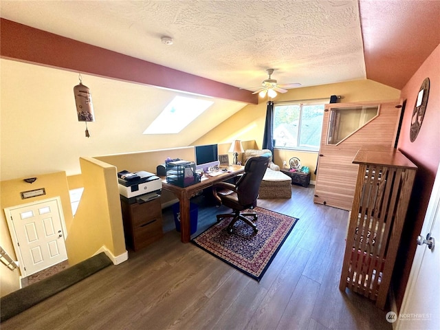 home office with a textured ceiling, hardwood / wood-style flooring, lofted ceiling with skylight, and ceiling fan