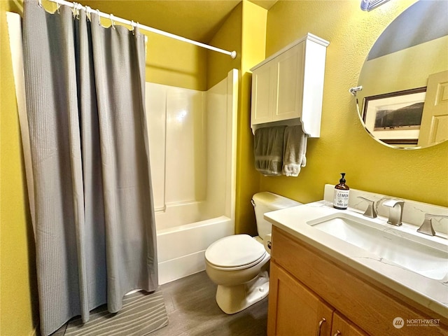 full bathroom featuring hardwood / wood-style floors, shower / bath combination with curtain, toilet, and vanity