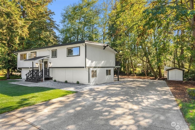 view of front of property with a front yard and a storage shed