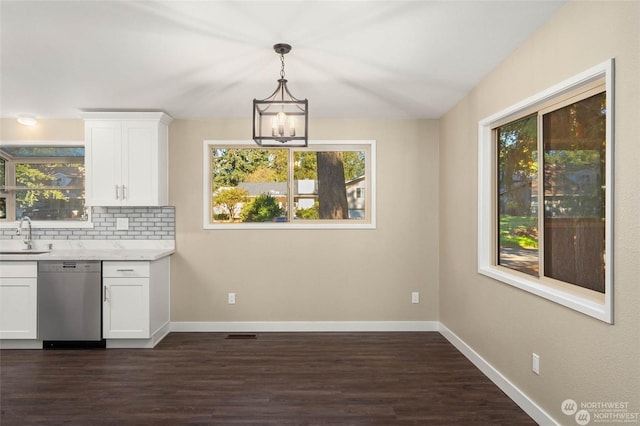 kitchen featuring pendant lighting, white cabinetry, sink, decorative backsplash, and stainless steel dishwasher