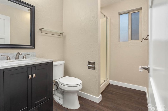 bathroom featuring hardwood / wood-style flooring, vanity, toilet, and walk in shower