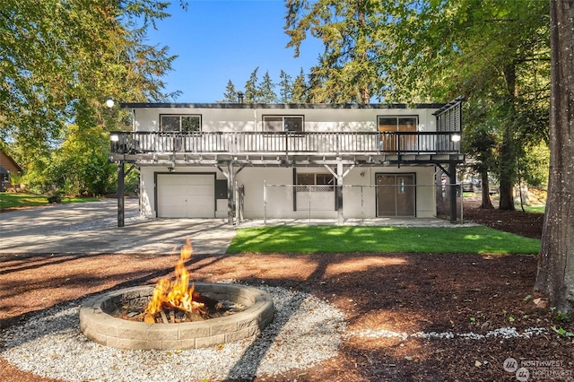 front facade with an outdoor fire pit, a deck, and a garage