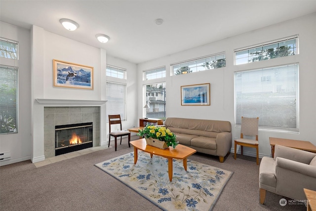 carpeted living room featuring a tile fireplace and a baseboard radiator