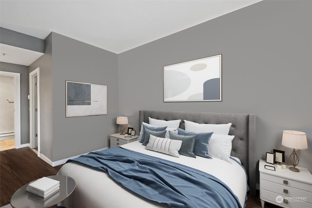 bedroom featuring dark hardwood / wood-style flooring and a baseboard heating unit