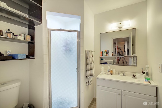 bathroom featuring vanity, toilet, and walk in shower