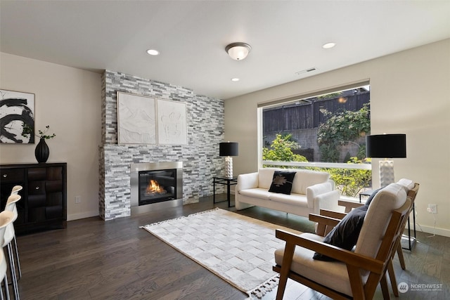 living room with a fireplace and dark wood-type flooring