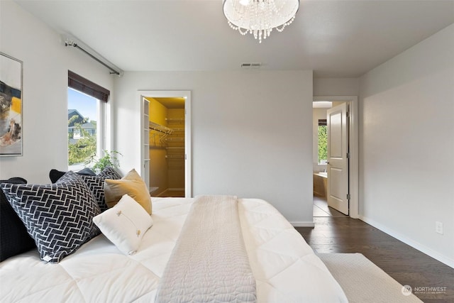 bedroom with a chandelier, wood-type flooring, a spacious closet, and a closet