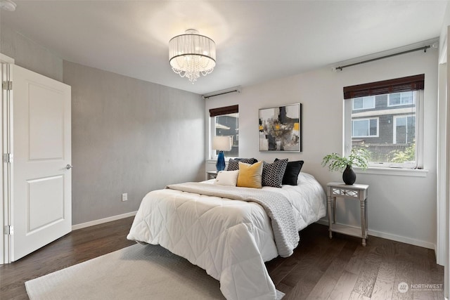 bedroom featuring dark hardwood / wood-style flooring and a notable chandelier