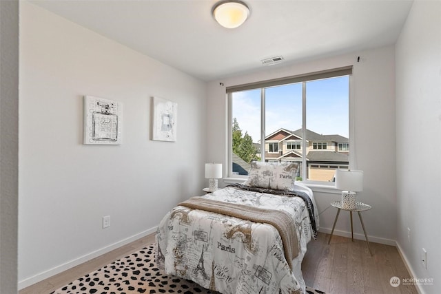 bedroom featuring multiple windows and light hardwood / wood-style floors