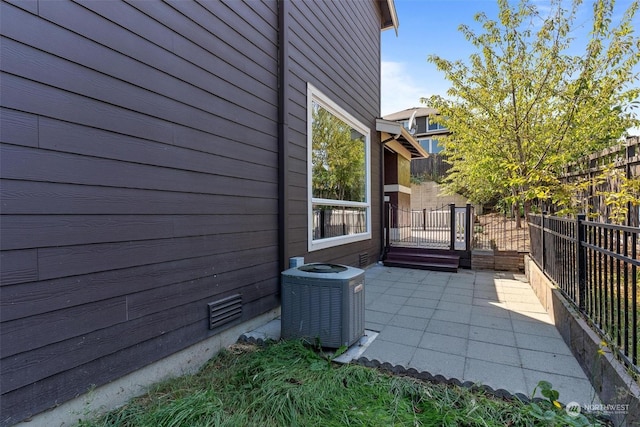 view of side of home featuring central air condition unit and a patio