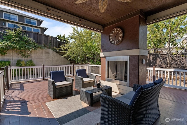 view of patio / terrace featuring an outdoor living space with a fireplace, ceiling fan, and a deck