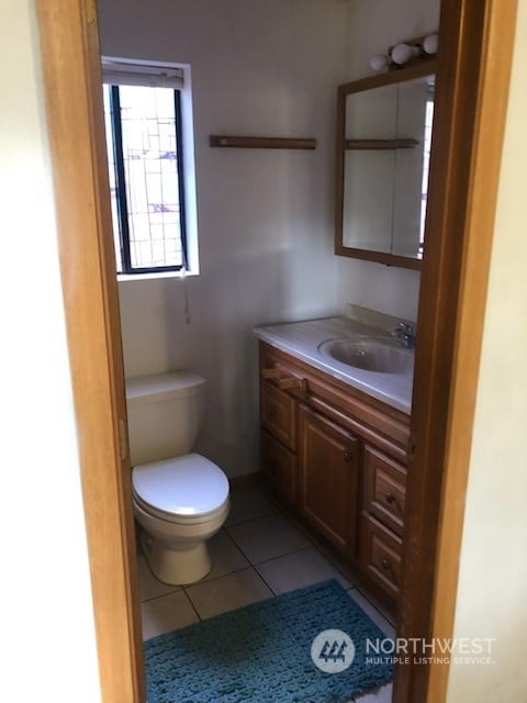 bathroom featuring tile patterned flooring, vanity, and toilet