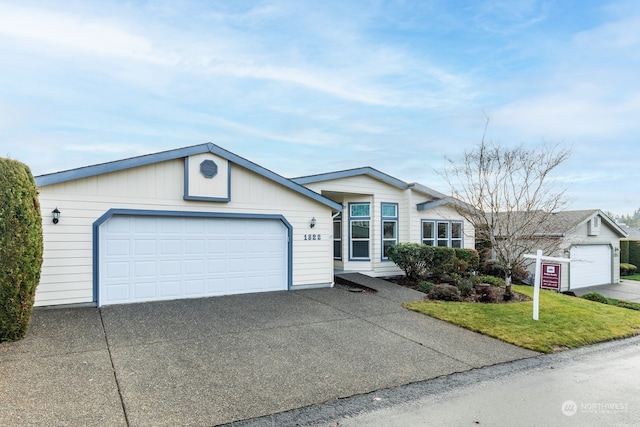 ranch-style home with a garage and a front lawn