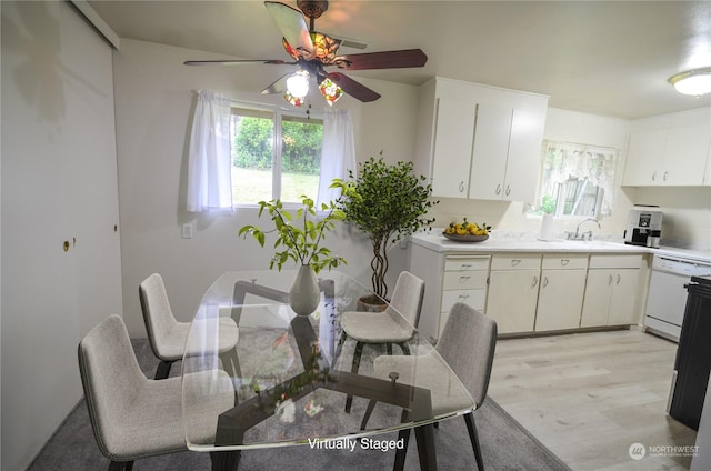 dining area with light hardwood / wood-style flooring, ceiling fan, and sink