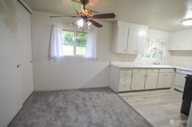 kitchen with ceiling fan, sink, white dishwasher, light hardwood / wood-style floors, and white cabinets