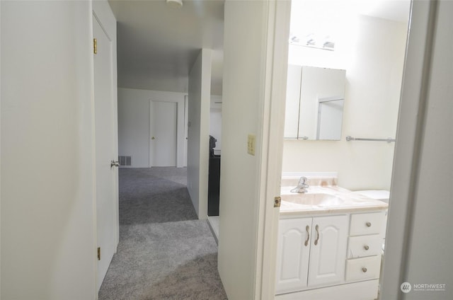 hallway featuring sink and light carpet