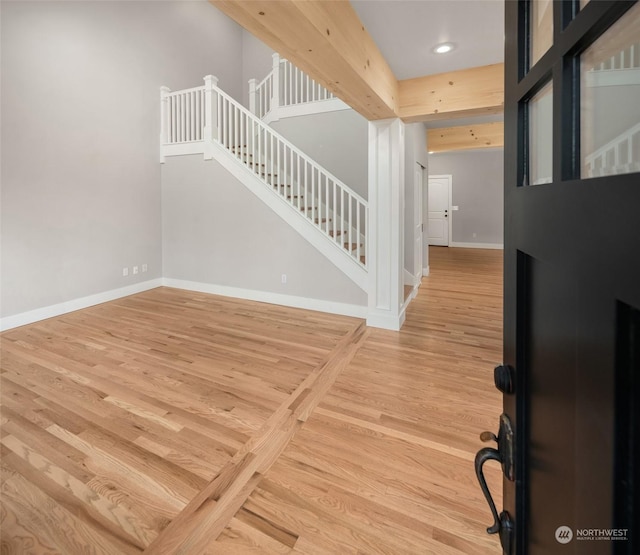 entrance foyer with light wood-type flooring and beam ceiling