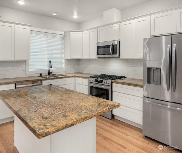 kitchen with stainless steel appliances, white cabinets, and sink