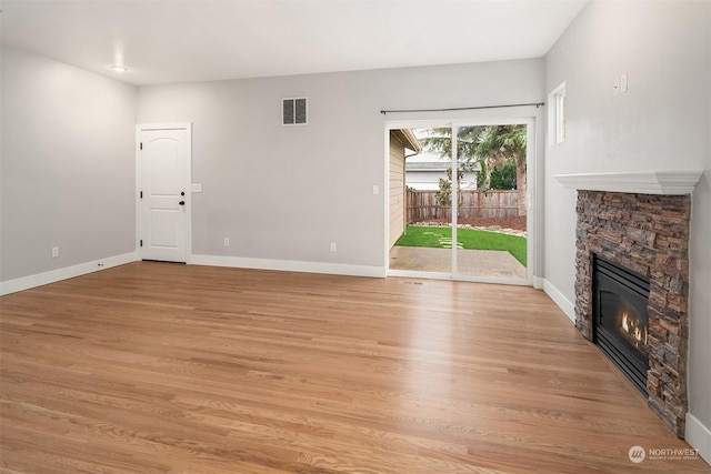 unfurnished living room with a fireplace and light hardwood / wood-style floors