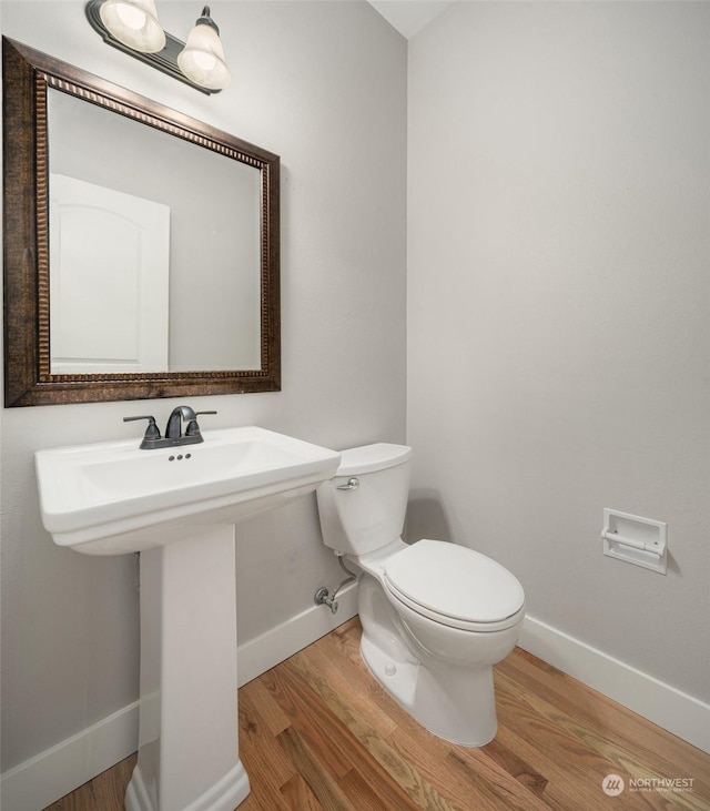 bathroom with toilet and hardwood / wood-style floors