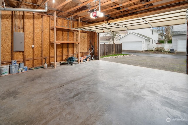 garage featuring a garage door opener, cooling unit, and electric panel