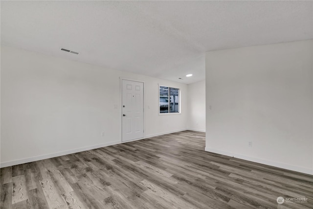 unfurnished room with wood-type flooring