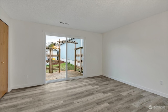 interior space with a textured ceiling, light hardwood / wood-style floors, and plenty of natural light