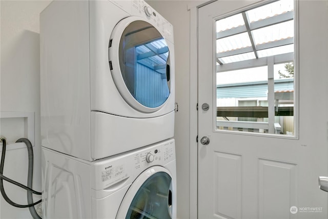 washroom featuring stacked washer and clothes dryer