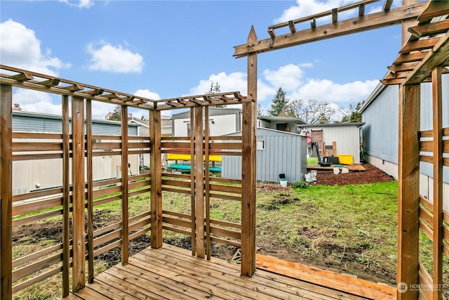 view of jungle gym with a storage unit, a pergola, and a wooden deck