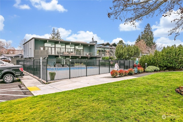 exterior space featuring a fenced in pool and a lawn