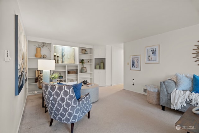 living room with built in shelves and light colored carpet