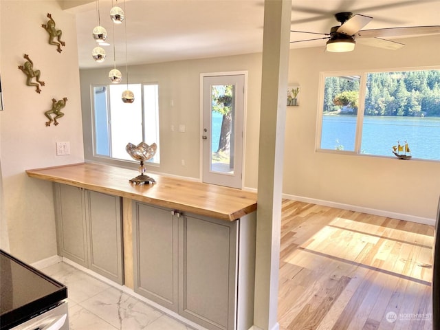 kitchen with butcher block countertops, gray cabinets, ceiling fan, and pendant lighting