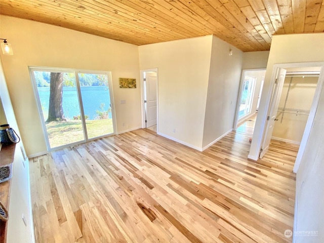 interior space featuring light hardwood / wood-style flooring, a water view, and wooden ceiling