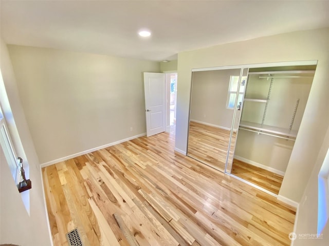 unfurnished bedroom featuring wood-type flooring and a closet