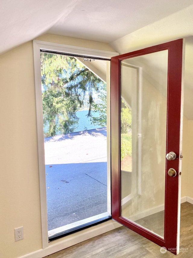 doorway to outside featuring hardwood / wood-style floors and lofted ceiling