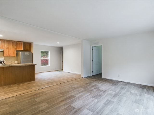 kitchen featuring stainless steel fridge and light hardwood / wood-style flooring