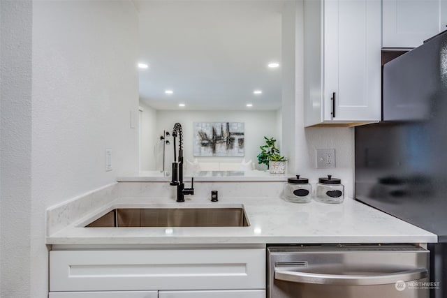 kitchen featuring light stone counters, sink, white cabinets, and appliances with stainless steel finishes