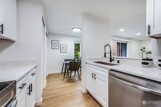 kitchen with light stone counters, sink, white cabinets, and appliances with stainless steel finishes